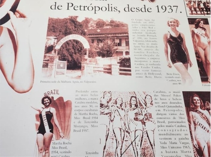 Painel na fábrica com fotos e textos sobre a história da moda praia em Petrópolis desde 1937, com os maiôs Catalina e as misses