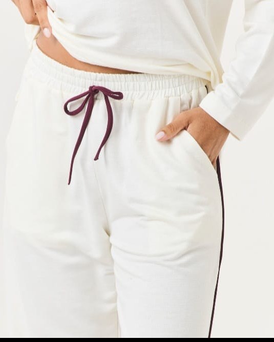 Detalhe da calça off white com cordão e vivo vinho