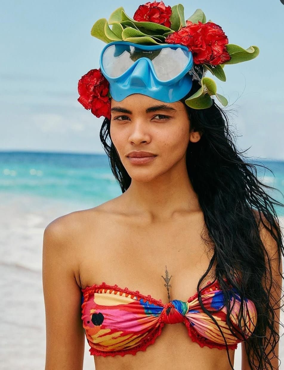 Modelo com top bandeau estampado e acabamento em crochê vermelho