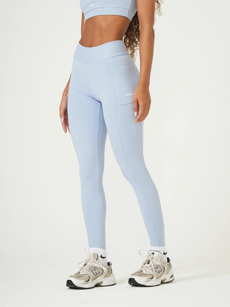 Modelo com top e legging fitness azul-claro e tênis