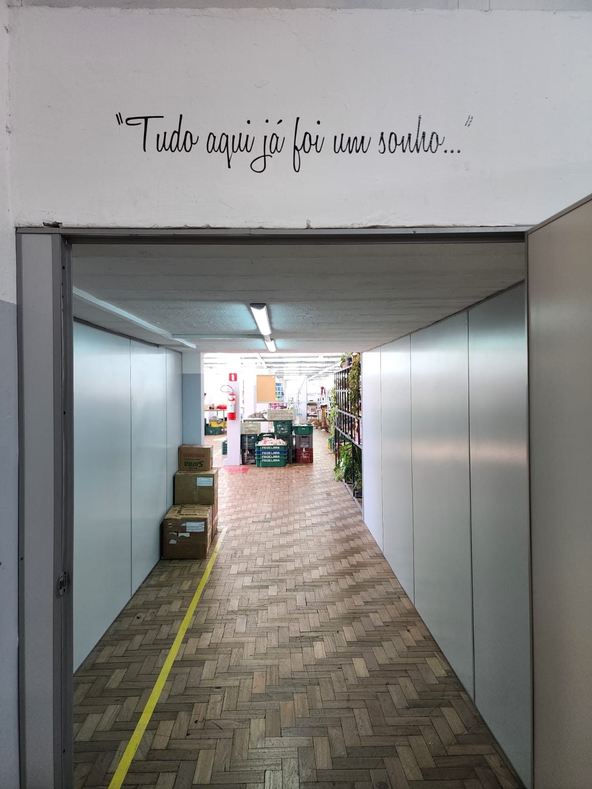 Corredor de entrada da fábrica, com a frase "Tudo aqui já foi um sonho" pintada na parede